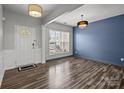 Bright living room with light gray walls, hardwood floors, and modern lighting fixtures, perfect for entertaining and relaxing at 11712 Huxley Rd, Charlotte, NC 28277