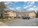 Exterior shot of brick condo building, showcasing parking and landscaped grounds at 1323 Queens Rd # 202, Charlotte, NC 28207