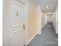 Hallway with neutral walls, gray carpet, doors, and overhead lighting fixtures at 1323 Queens Rd # 202, Charlotte, NC 28207