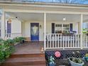 Inviting front porch with cream siding, purple shutters, and a blue door and offering a cozy outdoor seating area at 1906 Overhill Dr, Monroe, NC 28110