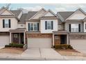 Charming townhome featuring a stone facade, attached garage, and landscaped front yard at 1915 Colony Line Ct, Charlotte, NC 28210