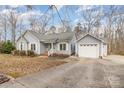 Inviting single-story home featuring a detached garage and long driveway surrounded by mature trees at 207 Cypress Dr, Gastonia, NC 28052