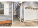 View between house and detached garage, featuring painted siding and a decorative sign at 207 Cypress Dr, Gastonia, NC 28052