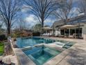 Stunning pool with spa features stone surround and comfortable seating areas, ideal for relaxation at 2326 Lathrop Ln, Charlotte, NC 28211