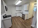 Well-lit kitchen features white cabinets, granite countertops, stainless steel appliances and wood-look flooring at 2766 Stagbuck Dr, Gastonia, NC 28052
