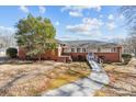 Traditional brick home featuring a ramp for accessibility and a well-kept lawn at 3120 Minnesota Rd, Charlotte, NC 28208