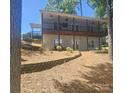 View of the backyard from the side of the home with landscaping and mature trees at 604 Fairway Shores Rd, Mount Gilead, NC 27306