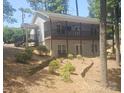 Beautiful two story home with a covered porch, gray siding, and mature trees at 604 Fairway Shores Rd, Mount Gilead, NC 27306