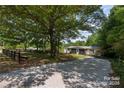 Single story home with a long gravel drive and lush mature trees at 6271 Sherwood Ln, Denver, NC 28037