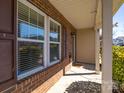 Covered front porch featuring brick accents, neutral siding, and a view of the landscaped yard at 649 Shellbark Dr, Concord, NC 28025