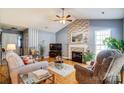 Inviting living room features a brick fireplace, vaulted ceiling, and neutral color palette at 7918 Travers Run Dr, Charlotte, NC 28215