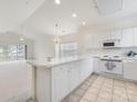 Open kitchen with breakfast bar, white cabinets, and seamless flow to living area at 8759 Coralbell Ln, Charlotte, NC 28213