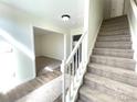 Bright foyer features neutral walls, wood-look floors, a decorative rug, and a carpeted staircase at 9146 Austin Ridge Ln, Charlotte, NC 28214