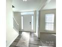 Bright foyer features a decorative rug, neutral walls, and a door with sidelights and a transom window at 9146 Austin Ridge Ln, Charlotte, NC 28214