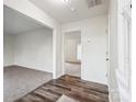 Open hallway with wood-look flooring and white trim, offering views into a living room and carpeted room at 9146 Austin Ridge Ln, Charlotte, NC 28214