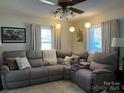 Comfortable living room featuring a large sectional sofa, neutral colors, and natural light from two windows at 9808 Arbor Dale Ave, Charlotte, NC 28215