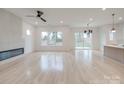 Spacious living room with light hardwood floors, large windows, and a modern fireplace at 0004 Mission Church Rd, Locust, NC 28097