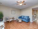 Cozy living room with hardwood floors, ceiling fan, and comfortable seating at 10901 Carmel Crossing Rd, Charlotte, NC 28226