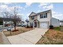 Inviting two-story home with an attached garage and long driveway, complemented by a neatly landscaped yard at 1301 Waylon Ave, Gastonia, NC 28054