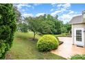 Well-maintained backyard featuring lush greenery, mature trees, and a patio area at 14309 Stonewater Ct, Fort Mill, SC 29707