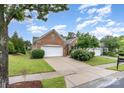 Charming brick home with manicured lawn, two car garage, and mature trees on a sunny day at 14309 Stonewater Ct, Fort Mill, SC 29707