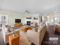 Bright living room featuring a fireplace, comfortable seating, and hardwood floors with views into the kitchen at 15633 Aviary Orchard Way, Charlotte, NC 28278