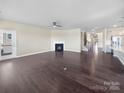 Spacious living room with hardwood floors, neutral paint, a fireplace, and abundant natural light at 15633 Aviary Orchard Way, Charlotte, NC 28278