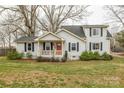 Traditional home featuring black shutters, a cozy porch, and a landscaped front yard at 1611 Old Hickory Grove Rd, Mount Holly, NC 28120