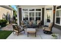 Inviting outdoor patio with cozy seating, a coffee table, and lush greenery, creating a serene ambiance at 16116 Lakeside Loop Ln, Cornelius, NC 28031