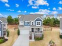 Charming two-story home with a welcoming front porch and landscaped yard, under a blue, partly cloudy sky at 1660 Sassafras Ct, Fort Mill, SC 29715