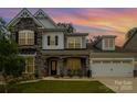 Charming two-story home with a stone facade, covered porch, manicured lawn, and two car garage at 17015 River Race Dr, Huntersville, NC 28078