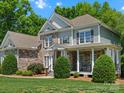 Craftsman home showcasing stone accents, light blue siding, and a cozy porch with seating at 1708 Meadow Crest Ct, Matthews, NC 28104