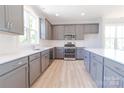 Modern kitchen features gray cabinets, stainless appliances, and white countertops at 210 Gilead Rd, Huntersville, NC 28078