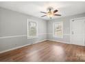 Bright bedroom with hardwood floors, neutral walls, ceiling fan, and two windows at 2407 Moose Rd, Kannapolis, NC 28083