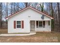 Charming one-story home featuring white siding, red roof, and a cozy front porch at 2407 Moose Rd, Kannapolis, NC 28083