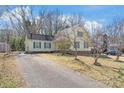 Charming yellow home featuring green shutters and a spacious driveway leading up to the residence at 6626 Somersworth Dr, Charlotte, NC 28215