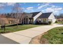Single Gathering home boasts inviting front porch, long driveway and well-manicured lawn at 7034 Pin Oaks Dr, Denver, NC 28037