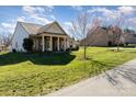 Well-maintained home featuring a lovely front lawn and a mix of stone and vinyl siding under a cloudy sky at 7034 Pin Oaks Dr, Denver, NC 28037