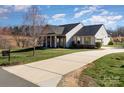 Attractive single-story home with a large driveway, well-kept lawn and appealing stone and siding at 7034 Pin Oaks Dr, Denver, NC 28037