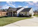 This charming home includes a well maintained lawn and an inviting covered front porch at 7034 Pin Oaks Dr, Denver, NC 28037