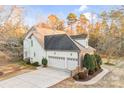 Rear exterior view of a two-story home with a three-car garage and concrete driveway at 8005 Bridger Pt, Waxhaw, NC 28173