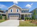 Inviting two-story home featuring a covered front porch, attached garage, and manicured lawn, creating a welcoming curb appeal at 9843 Quercus Ln, Huntersville, NC 28078