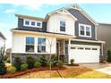 Charming two-story home with a mix of white board and batten, grey siding, stone accents, and a two-car garage at 9930 Cask Way, Huntersville, NC 28078