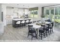 Spacious kitchen with white cabinets, a center island with bar seating, and an adjacent dining area at 9930 Cask Way, Huntersville, NC 28078