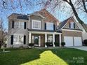 Charming two-story home with a well-manicured lawn, inviting front porch and a brick and siding facade at 114 Runningdeer Dr, Mooresville, NC 28117