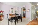 Elegant dining area with a chandelier, neutral walls, and dark wood table set for formal gatherings at 12031 Windy Rock Way # 1002, Charlotte, NC 28273