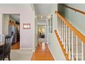 Inviting hallway featuring wood floors, neutral walls, staircase, and seamless transition to the dining and living areas at 12031 Windy Rock Way # 1002, Charlotte, NC 28273