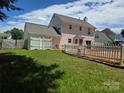 Spacious backyard featuring a refreshing in-ground swimming pool surrounded by a white picket fence at 14922 Rolling Sky Dr, Charlotte, NC 28273