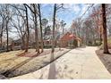 Inviting brick home with a long driveway, attached garage, and manicured lawn, surrounded by mature trees at 1531 Wheaton Nw Way, Concord, NC 28027