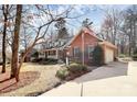 Traditional brick home with dormer windows, a covered porch, and lush landscaping creating a serene curb appeal at 1531 Wheaton Nw Way, Concord, NC 28027